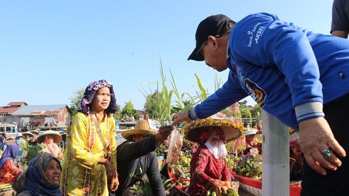 Pasar Terapung merupakan salah satu daya tarik wisata yang populer di Indonesia, terutama di daerah Kalimantan Selatan. Dengan keunikan cara berjualan di atas air, pasar ini tidak hanya menawarkan berbagai produk lokal, tetapi juga menciptakan pengalaman berbelanja yang berbeda bagi pengunjung. Salah satu kegiatan yang menarik perhatian publik adalah ketika Wakil Bupati Banjar, bersama Ketua Tim Penggerak PKK, melakukan pembelian langsung di pasar tersebut. Keberadaan mereka di sana bukan hanya sekadar untuk berbelanja, tetapi juga untuk mendukung para pedagang lokal, mempromosikan produk hasil pertanian, serta meningkatkan kesadaran masyarakat akan pentingnya pelestarian budaya lokal. Dalam artikel ini, kita akan membahas lebih dalam mengenai peran Wakil Bupati dan Ketua Tim Penggerak PKK dalam acara tersebut, dampaknya terhadap perekonomian lokal, serta bagaimana kegiatan ini dapat menjadi contoh bagi daerah lain. 1. Peran Wakil Bupati Banjar dalam Mendukung Ekonomi Lokal Wakil Bupati Banjar memiliki tanggung jawab besar dalam mengembangkan dan mendukung perekonomian daerah. Dalam konteks pasar terapung, kehadiran Wakil Bupati menjadi simbol dukungan pemerintah terhadap para pedagang lokal. Dengan berbelanja langsung di pasar, ia menunjukkan komitmen untuk meningkatkan perekonomian masyarakat. Pasar Terapung yang dikenal dengan produk-produk hasil pertanian dan perikanan merupakan salah satu sumber pendapatan bagi masyarakat setempat. Tindakan Wakil Bupati dalam memberdayakan pedagang lokal sangat penting. Dengan melakukan pembelian langsung, ia tidak hanya membeli produk, tetapi juga memberikan motivasi kepada pedagang untuk terus berinovasi dan mempertahankan kualitas produk. Dukungan semacam ini membantu meningkatkan kepercayaan diri para pedagang. Selain itu, dengan mengunjungi pasar, Wakil Bupati juga dapat mendengar langsung aspirasi dan keluhan para pedagang, yang bisa menjadi bahan pertimbangan dalam pengambilan keputusan di tingkat pemerintahan. Pemerintah juga dapat berperan lebih jauh dengan menyediakan fasilitas yang mendukung perdagangan di pasar terapung, seperti infrastruktur yang memadai, pelatihan untuk para pedagang, dan akses ke pasar yang lebih luas. Dengan langkah-langkah tersebut, diharapkan perekonomian lokal dapat tumbuh dan berkembang dengan baik. 2. Ketua Tim Penggerak PKK dan Pemberdayaan Perempuan di Pasar Terapung Ketua Tim Penggerak PKK juga memiliki peran yang sangat penting dalam kegiatan ini. PKK (Pemberdayaan dan Kesejahteraan Keluarga) adalah organisasi yang berfokus pada pemberdayaan perempuan di masyarakat. Dalam konteks pasar terapung, Ketua Tim Penggerak PKK berkontribusi dalam mendukung para wanita yang terlibat dalam perdagangan. Banyak pedagang di pasar terapung adalah perempuan yang mengelola usaha kecil mereka sendiri. Kehadiran Ketua Tim Penggerak PKK di pasar memberikan semangat dan dukungan moral bagi para perempuan pedagang. Selain itu, PKK juga dapat memberikan pelatihan dan pendampingan untuk meningkatkan kemampuan berwirausaha para wanita tersebut. Pelatihan tentang manajemen usaha, pengolahan produk, hingga teknik pemasaran bisa sangat membantu dalam meningkatkan kualitas dan daya saing produk yang mereka jual. Lebih jauh lagi, Ketua Tim Penggerak PKK dan anggotanya dapat menginisiasi program-program yang berfokus pada kesehatan dan pendidikan bagi keluarga-keluarga pedagang. Dengan demikian, keberadaan mereka tidak hanya berdampak pada ekonomi, tetapi juga berkontribusi pada peningkatan kualitas hidup masyarakat secara keseluruhan. 3. Dampak Sosial dan Ekonomi dari Kegiatan Borong di Pasar Terapung Kegiatan borong yang dilakukan oleh Wakil Bupati dan Ketua Tim Penggerak PKK di Pasar Terapung memiliki dampak yang signifikan terhadap masyarakat. Secara ekonomi, transaksi yang dilakukan langsung memberikan pendapatan tambahan bagi para pedagang. Hal ini tentu sangat membantu mereka, terutama di masa-masa sulit seperti saat pandemi. Keberadaan pejabat publik yang membeli produk mereka juga memberikan pengaruh positif terhadap citra pasar, menarik lebih banyak pengunjung untuk datang. Sosial, kegiatan ini dapat meningkatkan interaksi antara pemerintah dan masyarakat. Dengan terjun langsung ke lapangan, pemerintah menunjukkan kepedulian terhadap kondisi masyarakatnya. Ini juga menciptakan suasana yang lebih akrab dan terbuka, di mana masyarakat merasa memiliki ruang untuk menyampaikan aspirasi dan keluhan mereka. Lebih dari itu, kegiatan borong ini juga bisa menjadi ajang promosi bagi produk-produk lokal. Ketika pejabat publik menggunakan atau mengonsumsi produk lokal, hal ini bisa meningkatkan minat masyarakat untuk membeli produk yang sama. Dengan meningkatkan kesadaran akan produk lokal, diharapkan perputaran ekonomi di daerah tersebut dapat terus meningkat. 4. Pelestarian Budaya dan Tradisi Melalui Pasar Terapung Pasar Terapung bukan hanya sekedar tempat perdagangan, tetapi juga merupakan representasi budaya dan tradisi masyarakat. Melalui pasar ini, kita dapat melihat bagaimana cara hidup masyarakat lokal dan kearifan lokal yang diwariskan dari generasi ke generasi. Keberadaan pasar terapung dapat menjadi identitas yang kuat bagi masyarakat Banjar. Kegiatan yang dilakukan oleh Wakil Bupati dan Ketua Tim Penggerak PKK dalam pasar ini turut berkontribusi pada pelestarian budaya. Dengan mendukung pasar terapung, pemerintah menunjukkan pentingnya mempertahankan tradisi yang telah ada. Hal ini juga memberikan kesempatan bagi generasi muda untuk mengenal dan memahami budaya lokal mereka. Kegiatan pasar terapung bisa dikembangkan lebih lanjut menjadi festival budaya yang melibatkan berbagai elemen masyarakat. Dengan mengadakan festival, masyarakat bisa lebih mengenal produk lokal, seni, dan tradisi yang ada. Ini tidak hanya akan menarik wisatawan, tetapi juga memperkuat rasa cinta dan bangga terhadap budaya lokal.